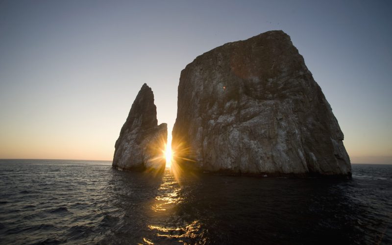 Genovesa Island, Ecuador --- Sun setting behind sea stack off Genovesa Island --- Image by © Mark Downey/Corbis